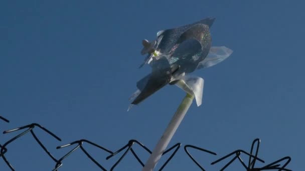 Windmolen speelgoed schoorvoetend spinnen in de wind — Stockvideo
