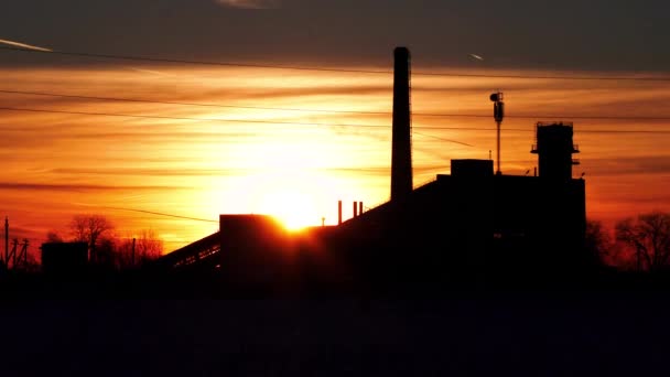 Старый заброшенный завод на фоне заходящего солнца в зимнее время видео — стоковое видео
