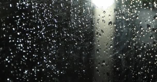 Regentropfen auf dem Glas in der Nacht vor dem Laternenpfahl — Stockvideo