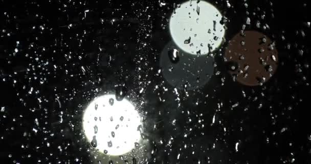 Krople deszczu na szkle przed światłem świateł nocnych bokeh — Wideo stockowe