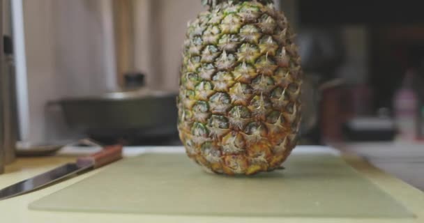 Las manos quitan la bolsa de celofán de la piña a la mesa de la cocina — Vídeo de stock