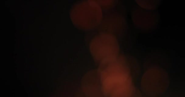 Bokeh lumineux et ardent des étincelles d'un feu sur un fond noir — Video