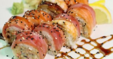 beyaz bir tabak üzerinde iştah açıcı suşi ekseni üst görünümü etrafında döner