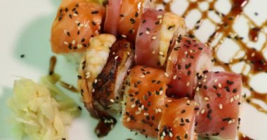 beyaz bir tabak üzerinde iştah açıcı suşi ekseni üst görünümü etrafında döner