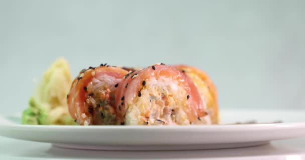 Ορεκτικό σούσι σε λευκό πιάτο περιστρέφεται γύρω από την πλευρική όψη του άξονα — Αρχείο Βίντεο