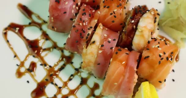 Appetizing sushi on a white plate revolve around its axis top view — Stock Video