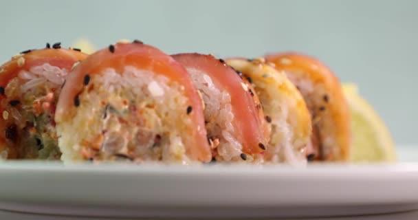 Sushi appetitoso su una piastra bianca ruotano intorno al suo asse vista laterale — Video Stock