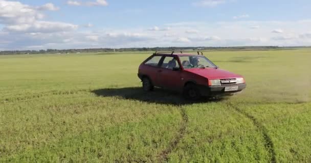 Coche rojo monta el campo y hace trucos — Vídeos de Stock