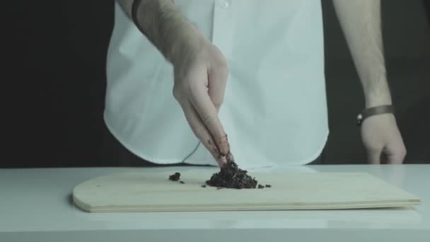 Hand zorgvuldig aanraakt en raakt zwarte tabak voor Shisha — Stockvideo