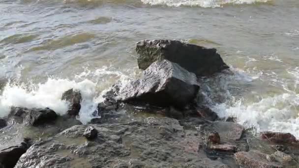 Piedras y el lento movimiento del agua en el mar durante el día — Vídeos de Stock