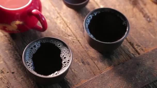 Zwei kleine Schalen mit Tee auf einem alten Holztisch — Stockvideo