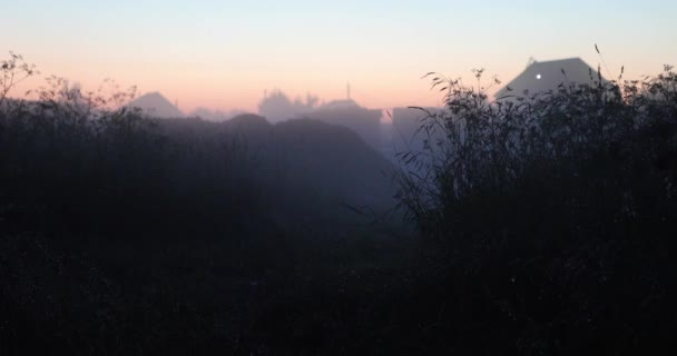 Vegetación natural y niebla por la noche en el fondo de las casas de pueblo — Vídeos de Stock