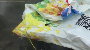 Suda bir plastik torba var, doğa kirliliği videosu 4K, yakın çekim. 