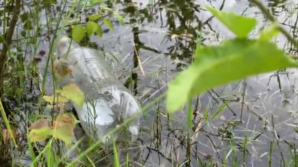 Пластиковая бутылка плавает в воде, 4k видео, крупным планом загрязнения воды — стоковое видео