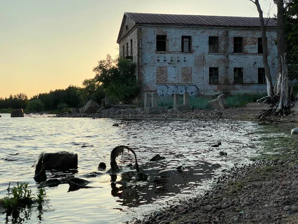 Edificio abbandonato vicino a uno stagno — Foto Stock