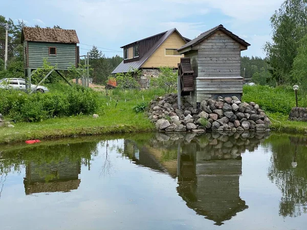Ancienne maison en bois, une cabane dans un village avec une petite fenêtre est située près d'un étang — Photo