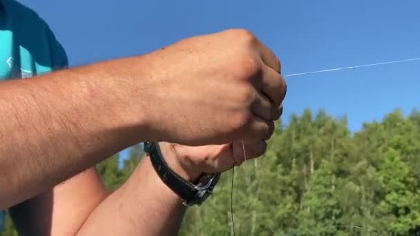 Mann bindet Knoten an Angelschnur, Nahaufnahme — Stockvideo