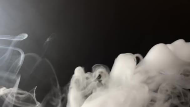 Puffs de fumaça de cigarro grosso branco no fundo preto — Vídeo de Stock