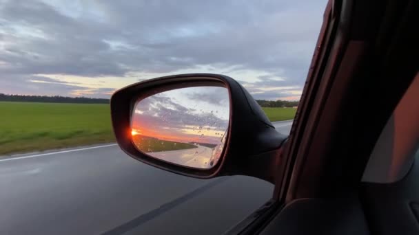 Відображення в бічному дзеркалі автомобіля під час водіння в літній вечір — стокове відео