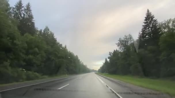 Путешествие на машине во время летнего дождя по проселочной дороге — стоковое видео