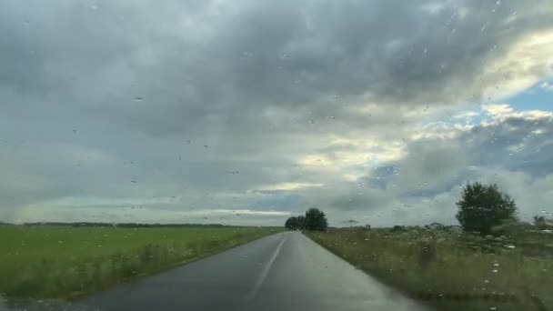 Viajando de carro durante uma chuva de verão em uma estrada rural — Vídeo de Stock