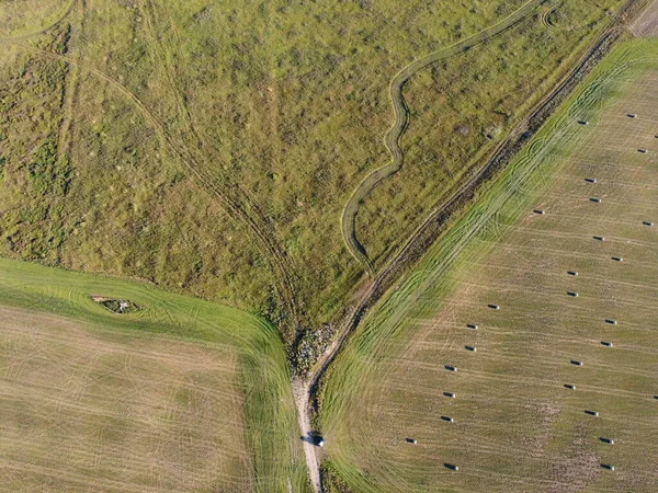 Hava fotoğrafında saman ruloları var.