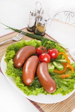 Domates, salatalık ve Yeşiller ile sosis haşlama. Siyah ya da beyaz ekmek ile servis. Mükemmel bir ek bir sıcak sos ve hardal var. Bu yemek yemek için güç ve neşe verir.