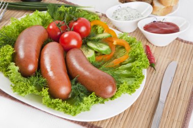 Domates, salatalık ve Yeşiller ile sosis haşlama. Siyah ya da beyaz ekmek ile servis. Mükemmel bir ek bir sıcak sos ve hardal var. Bu yemek yemek için güç ve neşe verir.