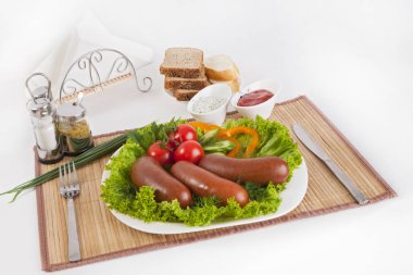 Domates, salatalık ve Yeşiller ile sosis haşlama. Siyah ya da beyaz ekmek ile servis. Mükemmel bir ek bir sıcak sos ve hardal var. Bu yemek yemek için güç ve neşe verir.