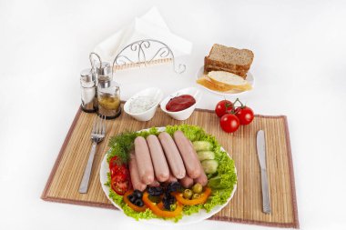 Domates, salatalık ve Yeşiller ile sosis haşlama. Siyah ya da beyaz ekmek ile servis. Mükemmel bir ek bir sıcak sos ve hardal var. Bu yemek yemek için güç ve neşe verir.