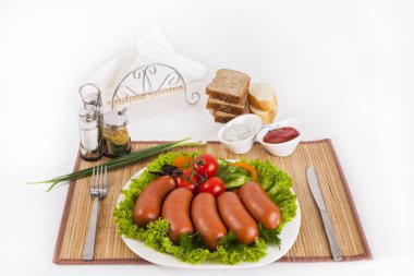 Domates, salatalık ve Yeşiller ile sosis haşlama. Siyah ya da beyaz ekmek ile servis. Mükemmel bir ek bir sıcak sos ve hardal var. Bu yemek yemek için güç ve neşe verir.