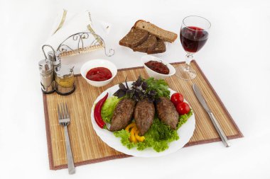 Yeşillik, domates ve salatalık ile beşamel sos. Siyah ya da beyaz ekmek ve bir kadeh kırmızı şarap ile hizmet vermektedir. Mükemmel bir ek bir sıcak sos ve hardal var. Bu yemek yemek için güç ve neşe verir.