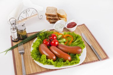 Domates, salatalık ve Yeşiller ile sosis haşlama. Siyah ya da beyaz ekmek ile servis. Mükemmel bir ek bir sıcak sos ve hardal var. Bu yemek yemek için güç ve neşe verir.