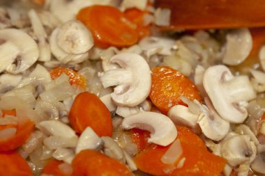 Soğan petrol mantar ve havuç bir tavada pişirilir.