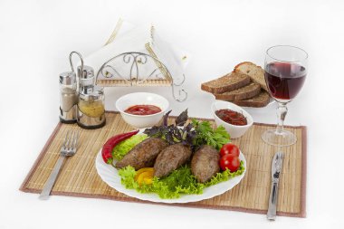 Yeşillik, domates ve salatalık ile beşamel sos. Siyah ya da beyaz ekmek ve bir kadeh kırmızı şarap ile hizmet vermektedir. Mükemmel bir ek bir sıcak sos ve hardal var. Bu yemek yemek için güç ve neşe verir.