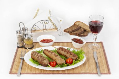 Lula Kebap domates ve salatalık ile. Siyah ya da beyaz ekmek ve bir kadeh kırmızı şarap ile hizmet vermektedir. Mükemmel bir ek bir sıcak sos ve hardal var. Bu yemek yemek için güç ve neşe verir.