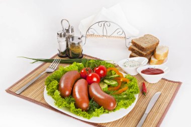 Domates, salatalık ve Yeşiller ile sosis haşlama. Siyah ya da beyaz ekmek ile servis. Mükemmel bir ek bir sıcak sos ve hardal var. Bu yemek yemek için güç ve neşe verir.