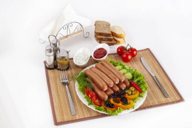 Domates, salatalık ve Yeşiller ile sosis haşlama. Siyah ya da beyaz ekmek ile servis. Mükemmel bir ek bir sıcak sos ve hardal var. Bu yemek yemek için güç ve neşe verir.