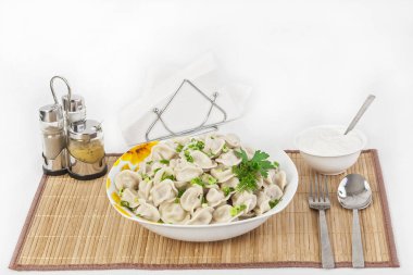 Otlar ve soğan ile Rus köfte. Etli mantı. Tabak bir tabak içinde servis edilir. Köfte ile hizmet ekşi krema bir kabın içinde olduğunu.