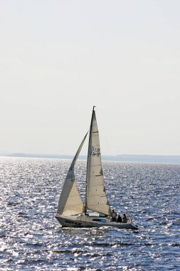 Güneş Volga Nehri boyunca yürüyüş Yelkenli. Güneş ışınları nehirde. Teknede üç kişi.