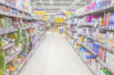 Bulanık fotoğraf. Büyük bir alışveriş merkezi ticaret salonu. Raflar parlak renkli ürünler ile düz satırları.