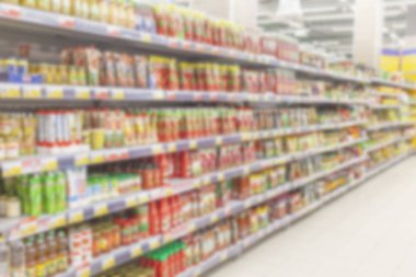 Bulanık fotoğraf. Büyük bir alışveriş merkezi ticaret salonu. Raflar parlak renkli ürünler ile düz satırları.