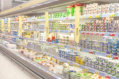 Bulanık fotoğraf. Büyük bir alışveriş merkezi ticaret salonu. Raflar parlak renkli ürünler ile düz satırları.