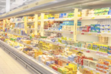 Bulanık fotoğraf. Büyük bir alışveriş merkezi ticaret salonu. Raflar parlak renkli ürünler ile düz satırları.