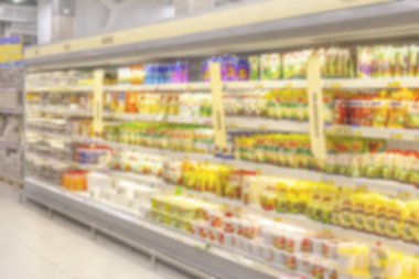 Bulanık fotoğraf. Büyük bir alışveriş merkezi ticaret salonu. Raflar parlak renkli ürünler ile düz satırları.