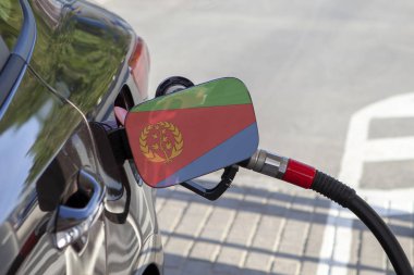 Eritre bayrağı otomobilin yakıt tankı dolgu üzerinde kapak. Yakıt araba benzin istasyonunda benzin pompası ile. Benzin istasyonu. Benzin ve petrol ürünleri. Yakın çekim.