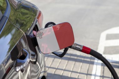 Malta bayrağı otomobilin yakıt tankı dolgu üzerinde kapak. Yakıt araba benzin istasyonunda benzin pompası ile. Benzin istasyonu. Benzin ve petrol ürünleri. Yakın çekim.