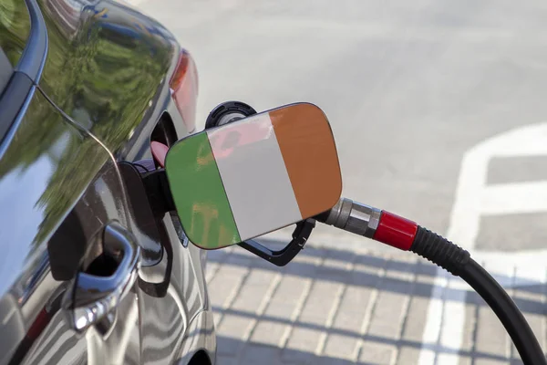 Flag of  Irlande on the car\'s fuel tank filler flap. Fueling car with petrol pump at a gas station. Petrol station. Gasoline and oil products. Close up.