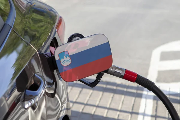 Flag of  on the car's fuel tank filler flap. Fueling car with petrol pump at a gas station. Petrol station. Gasoline and oil products. Close up.