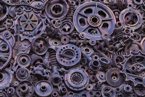 Steampunk background, machine parts, large gears and chains from machines and tractors. Old rusty machine parts. Springs, bearings, pistons, crankshafts, camshafts.